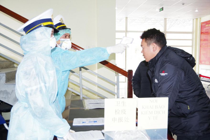 Kiểm tra thân nhiệt người nhập cảnh vào Việt Nam qua cửa khẩu Ma Lù Thàng (Lai Châu). Ảnh: PV 