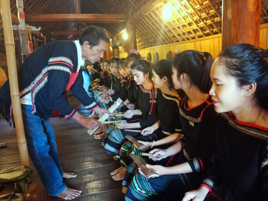 Nghệ nhân Y Hiu hướng dẫn các bạn trẻ đánh chiêng tre 