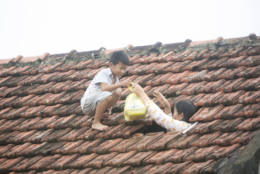 Một em bé ở Lệ Thuỷ, Quảng Bình xin được đồ cứu trợ mang về cho mẹ Ảnh: Trọng Tài 