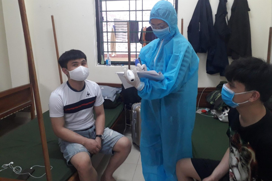 Trung úy Ngô Thị Vân Anh kiểm tra, ghi chép tình hình sức khỏe công dân ở khu cách ly. ẢNH: PV 