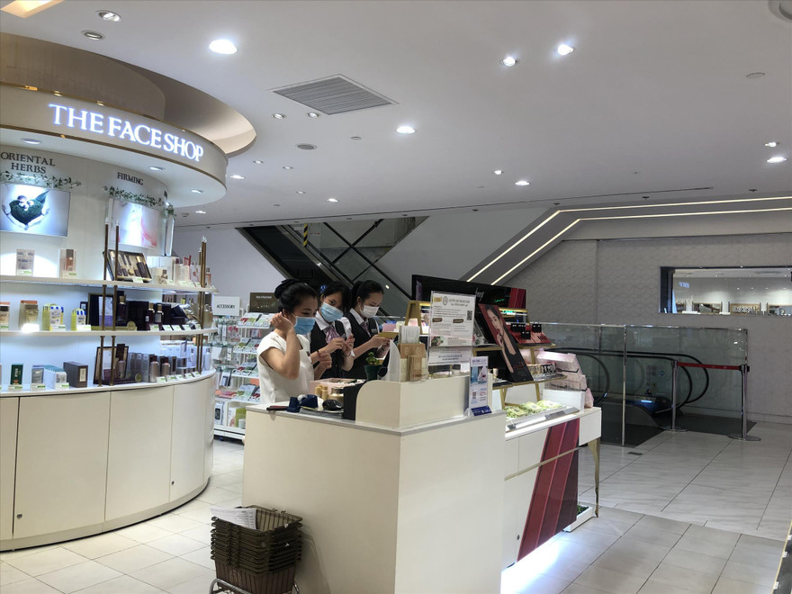 Nhân viên cửa hàng mỹ phẩm đeo khẩu trang tiếp khách
