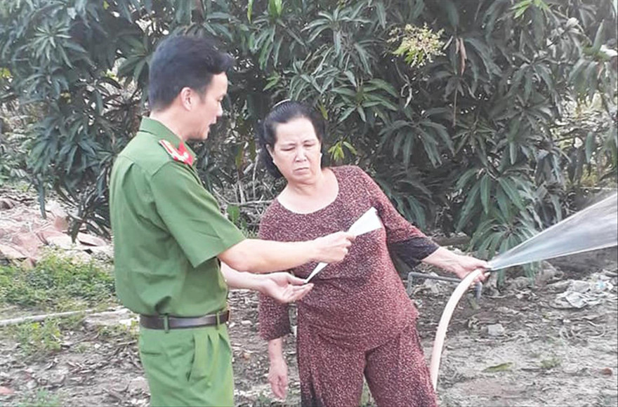 Công an tỉnh Bình Dương phát tờ rơi đến người dân để nhận diện đối tượng Lê Quốc Tuấn