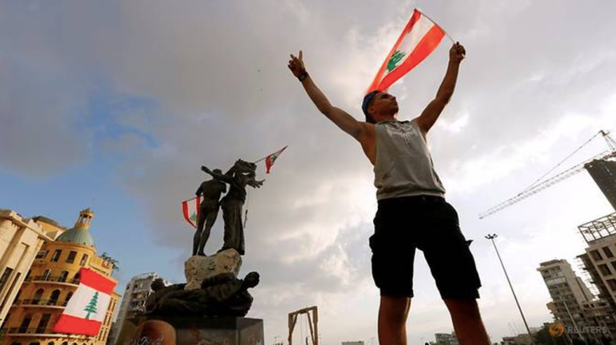 Một người biểu tình giương cờ Li-băng trên Quảng trường Liệt sĩ ngày 9/8 