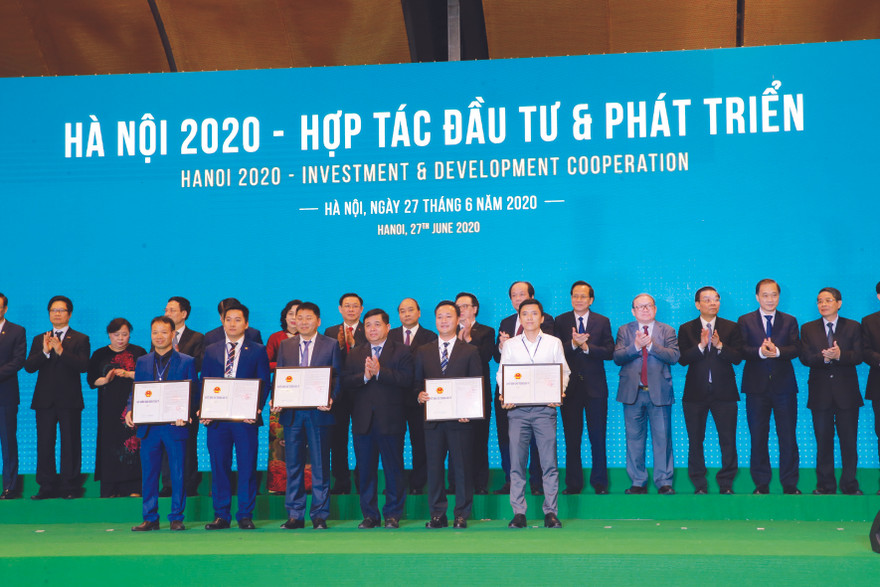 Ông Nguyễn Việt Hùng - Bí thư Ðảng ủy, Chủ tịch HÐTV HUD (Hàng đầu, thứ hai, từ phải sang) nhận Quyết định chủ trương đầu tư Dự án NƠXH HUD Vân Canh tại Hội nghị Hợp tác đầu tư & phát triển do TP Hà Nội tổ chức vào tháng 6/2020 ​