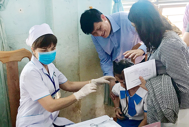 Ông Nguyễn Thanh Long thăm trẻ tiêm vắc-xin ngừa bạch hầu tại huyện Ðắk Ðoa, tỉnh Gia Lai . Ảnh: T.Hà