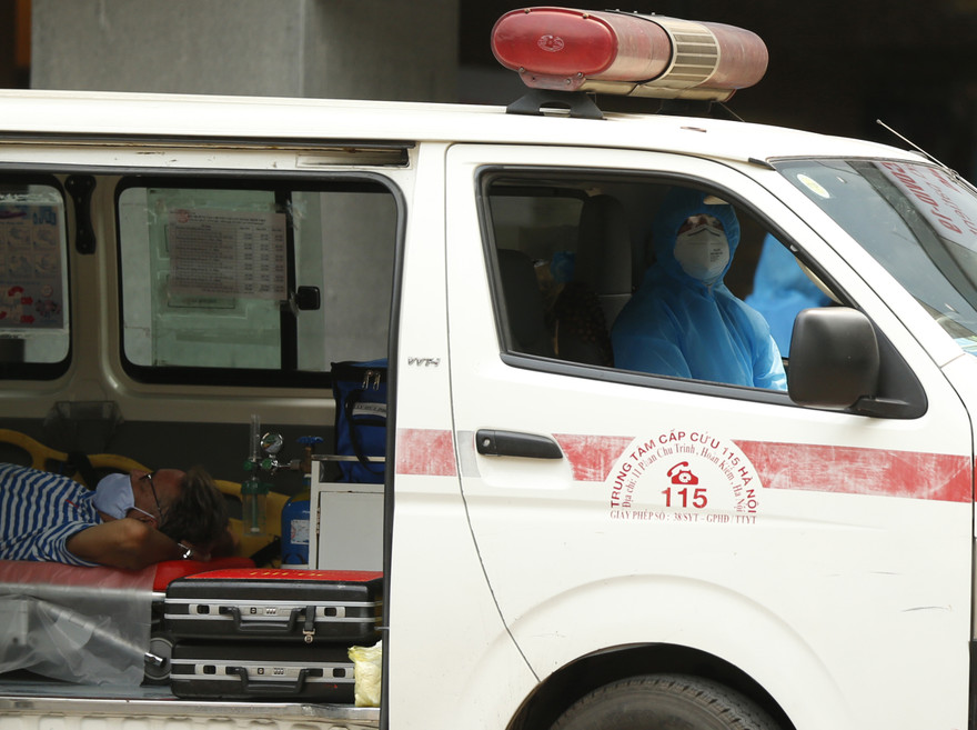 Nhân viên y tế đưa người nước ngoài vào khu xét nghiệm COVID-19 tại Bệnh viện Việt Pháp- Hà Nội sáng 26/3 Ảnh: Như Ý