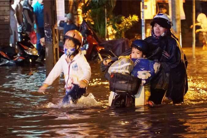 Người dân bất lực trước đường ngập. Ảnh: Ngô Bình.