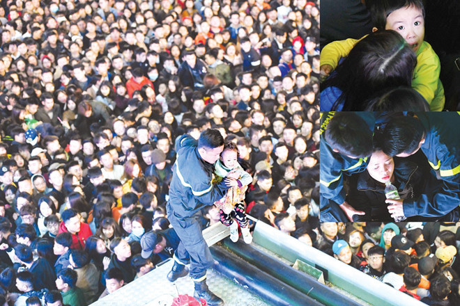 Lính cứu hỏa giải cứu trẻ em và phụ nữ giữa biển người chen lấn ở khu vực phố đi bộ Hồ Gươm, đêm 31/12/2017. Ảnh: Tiến Tuấn.