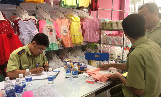 Lực lượng QLTT kiểm tra hàng hóa tại một cửa hàng Con Cưng. Ảnh: H.T.