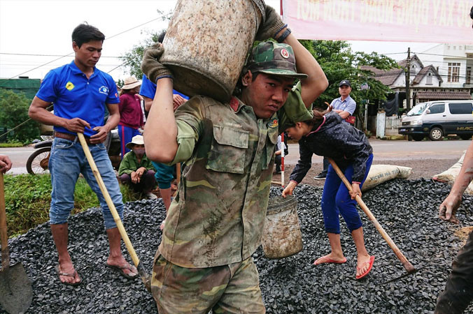 Chiến sĩ Trung đoàn 66 cùng ÐVTN làm giao thông nông thôn ở buôn A Riêng. Ảnh: V.L.