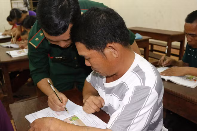 Trung úy Trần Thế Mạnh hướng dẫn học viên viết chữ trong một buổi học. Ảnh: B.S.