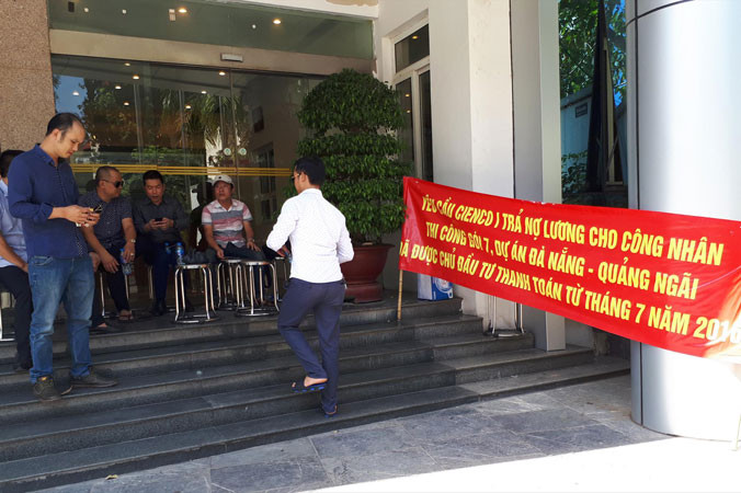 Người của Cienco 8 căng biển, kê ghế chắn cửa Cienco 1 đòi nợ. Ảnh: TX.