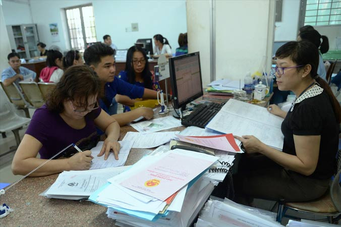 Người dân làm thủ tục cấp giấy chứng nhận nhà đất tại UBND huyện Hóc Môn.