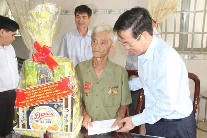 Ông Võ Văn Thưởng tặng quà cho thương binh Nguyễn Trung Bình. Ảnh: M.T.