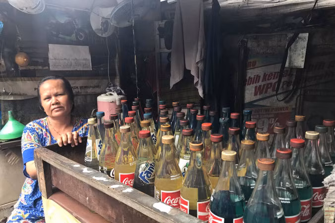 Một điểm bán xăng trong khu phố nghèo ở Jakarta. Xăng được đựng trong những vỏ chai nước ngọt đã qua sử dụng. Ảnh: NP.