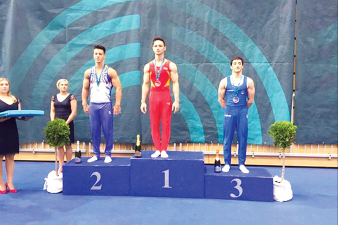 Đinh Phương Thành (giữa) trên bục nhận HCV xà kép. Ảnh: HLV Trương Minh Sang.