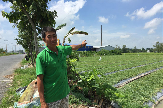 Ông Võ Văn Mười chỉ ống khói cơ sở nhôm xả thải gây ô nhiễm.