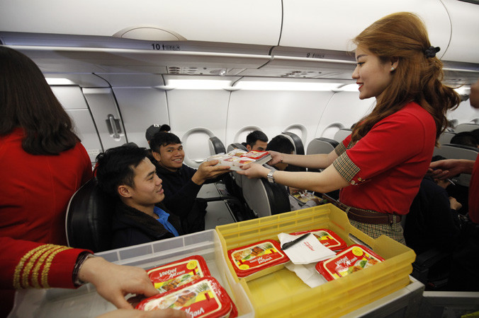 Các cầu thủ U23 vui vẻ đón nhận những suất ăn được tiếp viên hàng không Vietjet chăm sóc nhiệt tình.