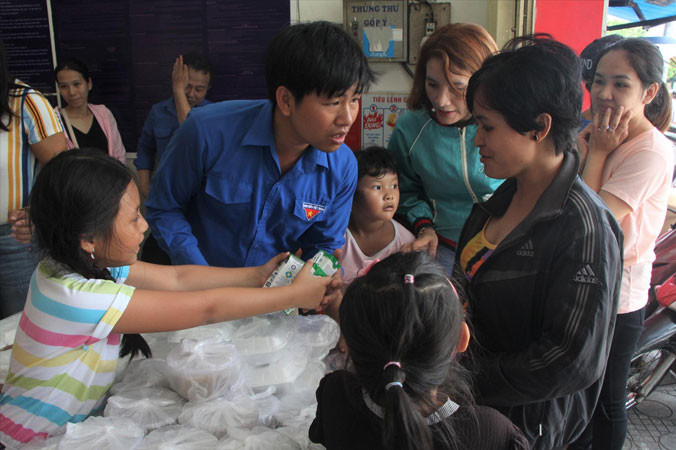 Gửi tặng những phần cơm nghĩa tình đến người lao động nghèo. Ảnh: NGÔ TÙNG.