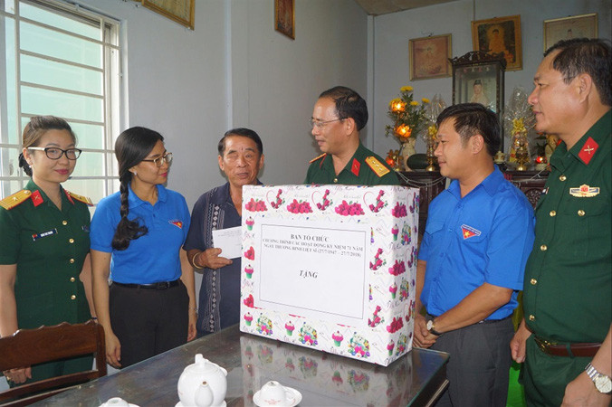 Thượng tá Ðinh Quốc Hùng, Trưởng ban Thanh niên Quân đội thăm hỏi, tặng quà cho thương binh Nguyễn Văn Chuyên. Ảnh: N.M.