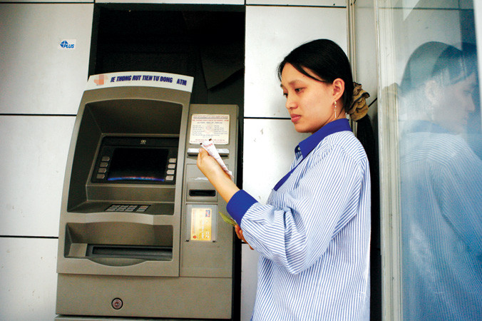 Với người có điều kiện, việc trừ một vài chục ngàn đồng trong tài khoản có thể là việc nhỏ, nhưng với công nhân thì đó là cả vấn đề. Ảnh: Hồng Vĩnh.