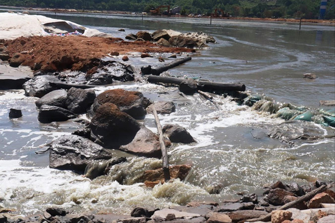 Nước rỉ đen ngòm từ túi bùn chảy về hướng vịnh Chân Mây.