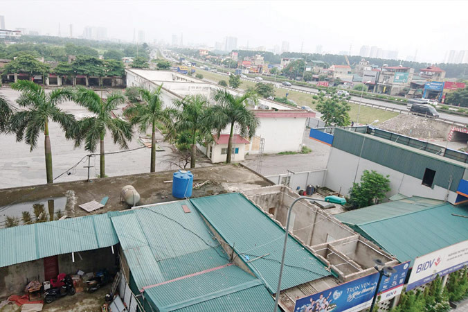 Khu vực đất được quyết định làm Bến xe Yên Sở, phía trước là nút giao vành đai 3 - cao tốc Pháp Vân và lọt giữa các khu chung cư,đô thị mới. Ảnh: Phạm Thanh.