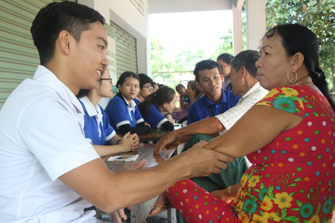 Chiến sỹ Mùa hè xanh trường ÐH Y dược TPHCM chăm sóc sức khỏe người dân. Ảnh: NGÔ TÙNG.