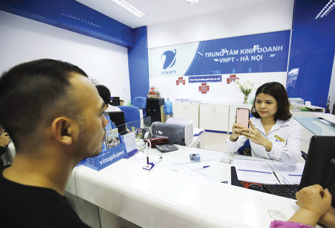 Khách hàng chụp ảnh chân dung tại địa điểm giao dịch của một nhà mạng. Ảnh: Như Ý.