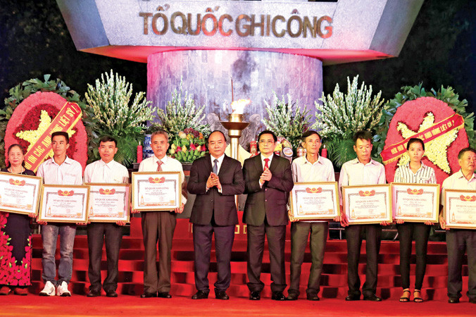 Thủ tướng Nguyễn Xuân Phúc và Trưởng ban Tổ chức Trung ương Phạm Minh Chính trao Bằng Tổ quốc ghi công cho đại diện thân nhân các liệt sỹ. Ảnh: Thống Nhất.