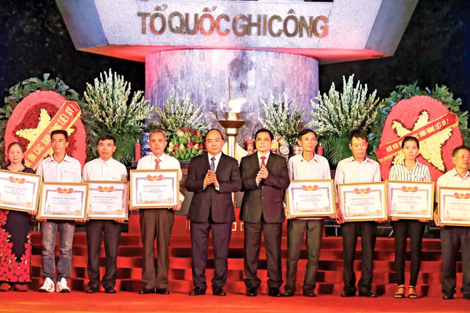 Thủ tướng Nguyễn Xuân Phúc và Trưởng ban Tổ chức Trung ương Phạm Minh Chính trao Bằng Tổ quốc ghi công cho đại diện thân nhân các liệt sỹ. Ảnh: Thống Nhất.