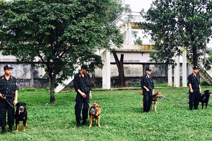 Huấn luyện viên cùng cảnh khuyển đứng nghiêm nghe hiệu lệnh.