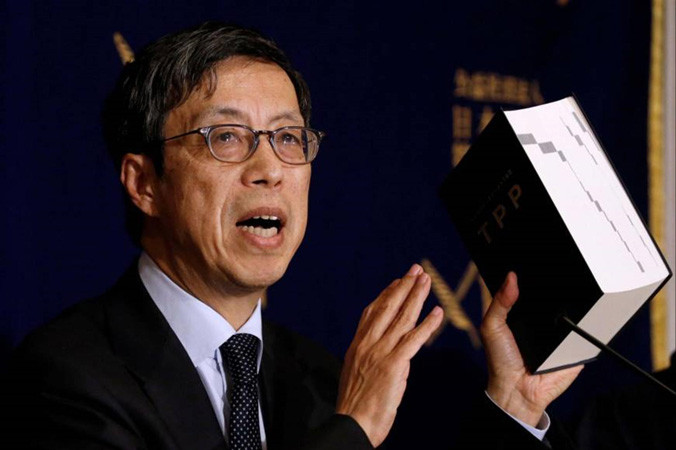 Ông Kazuyoshi Umemoto, trưởng đoàn đàm phán Nhật Bản về CPTPP, cầm trên tay phiên bản TPP ban đầu tại một cuộc họp báo hôm 20/2 ở Tokyo. Ảnh: Getty Images.