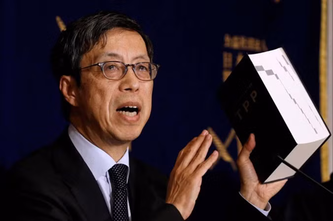 Ông Kazuyoshi Umemoto, trưởng đoàn đàm phán Nhật Bản về CPTPP, cầm trên tay phiên bản TPP ban đầu tại một cuộc họp báo hôm 20/2 ở Tokyo. Ảnh: Getty Images.