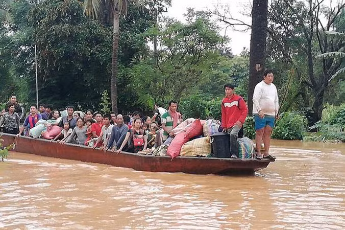 Người dân vùng bị ngập lụt được đưa đi sơ tán bằng thuyền. Ảnh: Vientiane Times.