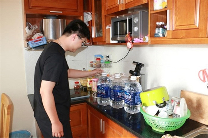  Một gia đình tại chung cư TSQ Euroland dự trữ số nước ít ỏi vừa lấy được từ xe stec.
