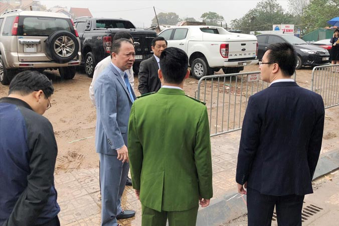 Có đủ lực lượng trong tay, nhưng sáng 22/2 khi được đại diện HĐND Hà Nội chất vấn, Phó Chủ tịch quận Tây Hồ Nguyễn Lê Hoàng (thứ 2, từ trái) chỉ đứng nhìn bãi xe lậu (phía sau) hoạt động.