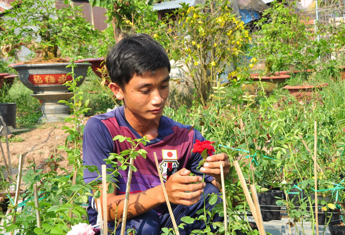Anh Nguyễn Bé Tâm chăm sóc hoa. Ảnh: Hòa Hội.