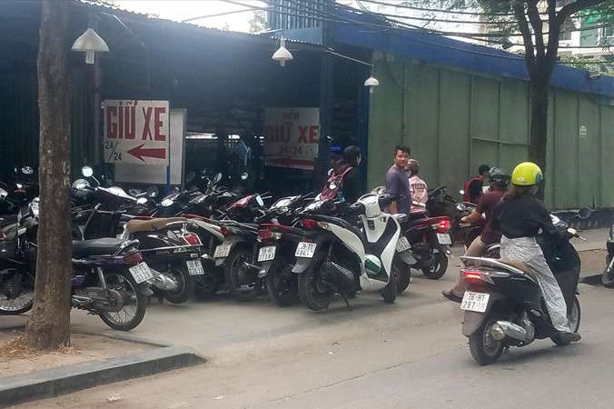 Nhiều bãi giữ xe máy nội thành quá tải lấn chiếm vỉa hè làm nơi để xe. Ảnh: Ngô Bình.