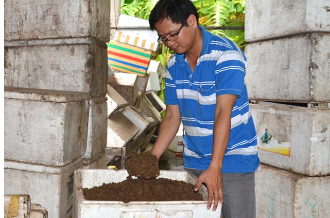 Anh Trần Phúc Hậu với chế phẩm vi sinh từ bột bã mía. Ảnh: N.D