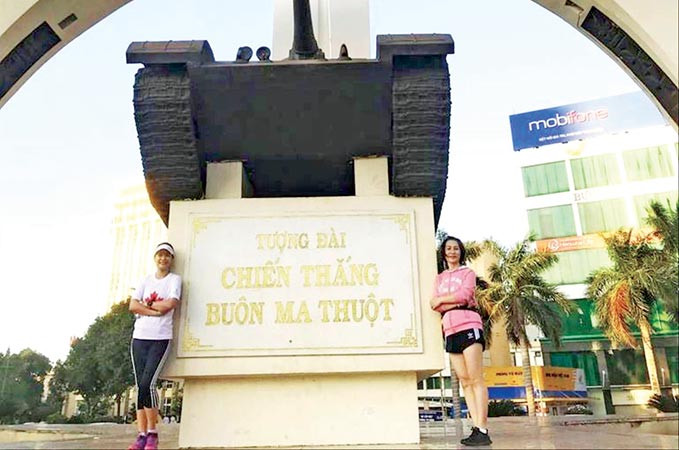 Hồng Thủy (trái) bên Tượng đài Chiến thắng, ngã 6 Buôn Ma Thuột trong một buổi tập chạy. Ảnh:NVCC.