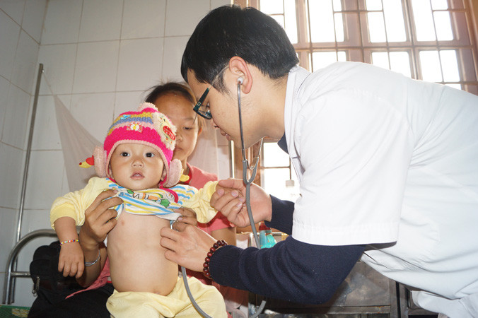 Bác sĩ Nguyễn Văn Hiếu thăm khám cho bé gái Giàng Thị Du Lăm ở bản Chuyên Gia 1 (xã Nậm Kè, huyện Mường Nhé). Ảnh: Nguyễn Minh.