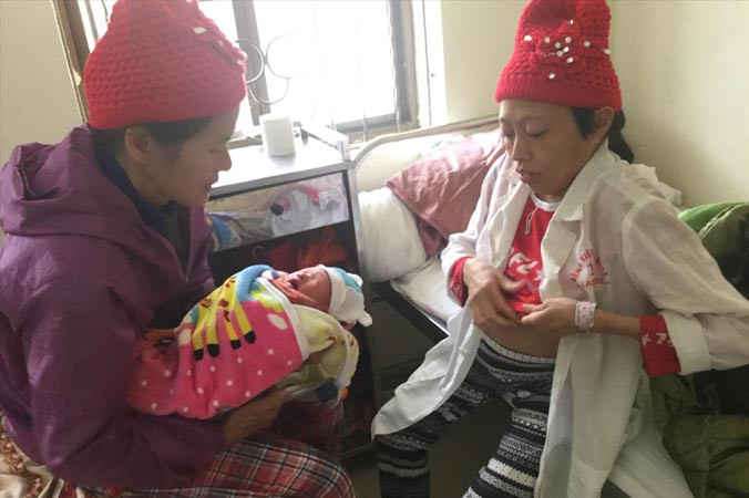 Chị Quyên (bìa phải) cùng bà nội sung sướng chăm sóc con trai. Ảnh: Duy Chiến.