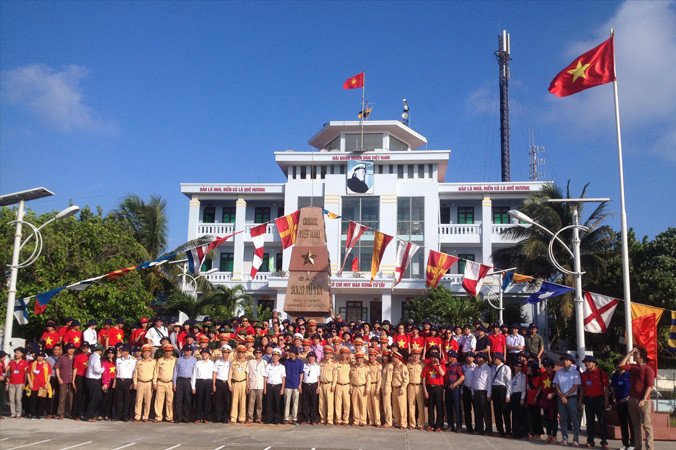 Đoàn công tác số 10, trong đó có gần 70 kiều bào từ 24 quốc gia, chụp ảnh lưu niệm tại cột mốc chủ quyền đảo Song Tử Tây. Ảnh: L.A