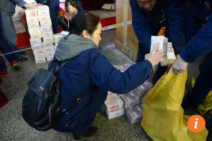 Một công nhân nhà máy thép Phương Đại đang đếm tiền thưởng cho vào bao tải. Ảnh: QQ.