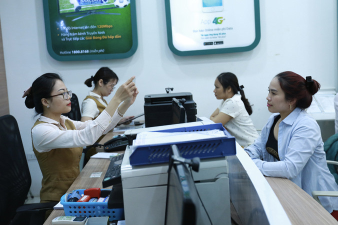 Khách hàng chờ đến lượt cập nhật thông tin người dùng tại một điểm cung cấp dịch vụ viễn thông của Viettel. Ảnh: Như Ý.