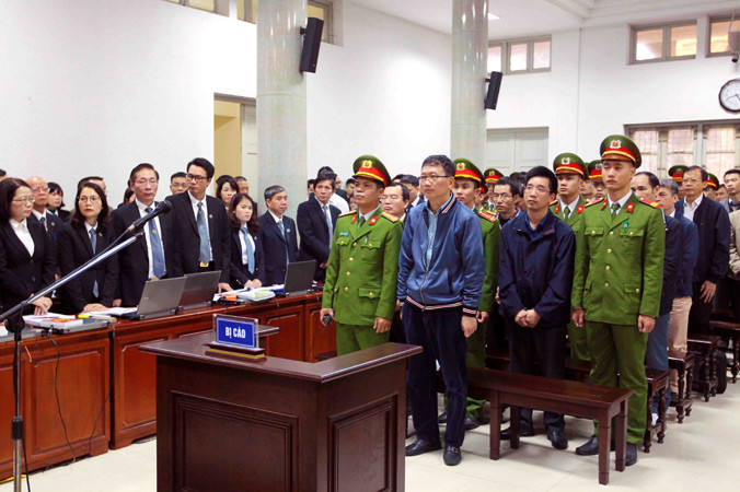 Các bị cáo nghe Hội đồng xét xử công bố quyết định đưa vụ án ra xét xử. Ảnh: TTXVN.
