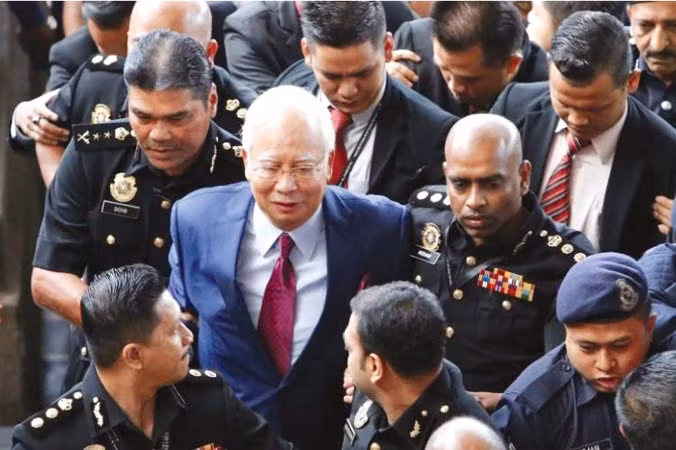 Cựu Thủ tướng Najib Razak rời tòa trước sự bao vây của báo chí. Ảnh: Straits Times.
