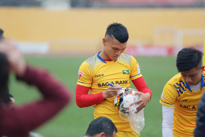 Phạm Xuân Mạnh và Phan Văn Đức ký tên vào quả bóng lưu niệm dành cho người hâm mộ tại buổi tập. Ảnh: Hồng Vĩnh.