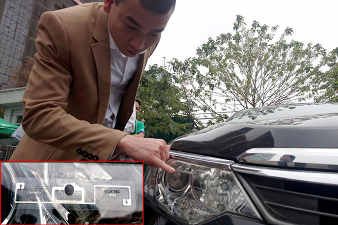 Chủ xe thử độ bám dính của thẻ thu phí không dừng dán trên đèn xe. Ảnh: PT.